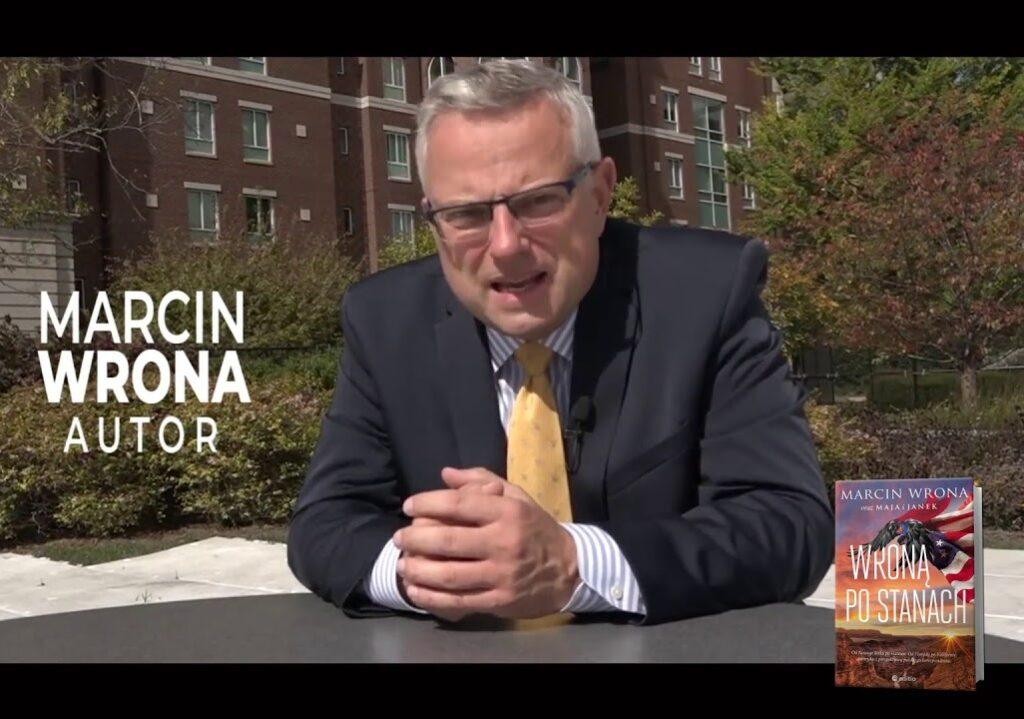 Marcin Wrona relacjonujący na żywo z Waszyngtonu, z mikrofonem TVN w ręku.