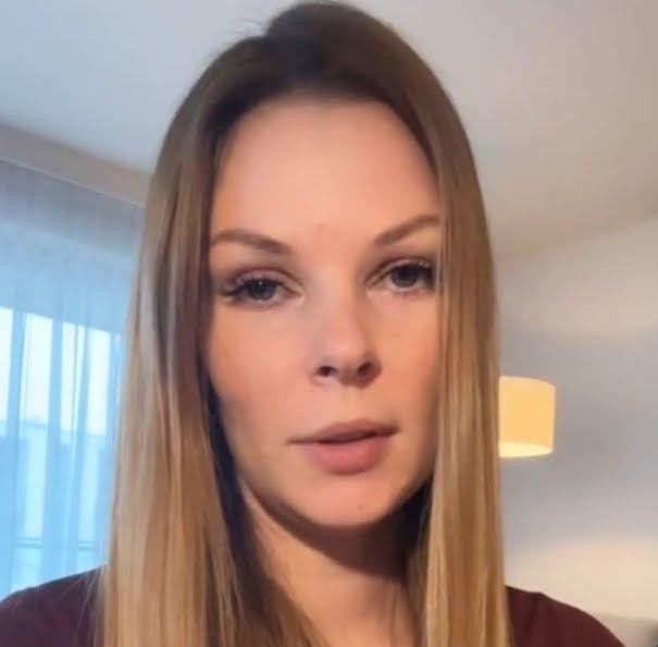 Małgorzata Tomaszewska podczas prowadzenia programu telewizyjnego, pełna energii i profesjonalizmu, w tle subtelne elementy studia.