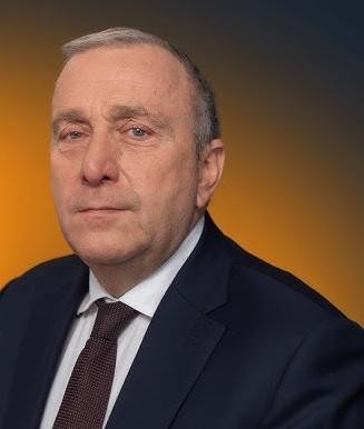 Grzegorz Schetyna w trakcie wystąpienia publicznego, z dynamicznym wyrazem twarzy, na tle parlamentarnej sali.