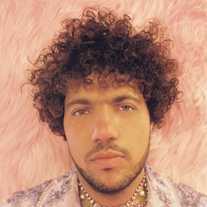 Benny Blanco w studiu nagraniowym, aktywnie pracujący nad muzyką, otoczony sprzętem studyjnym.