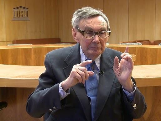 Marian Turski podczas przemówienia, z wyrazem determinacji i zadumy, podkreślający wagę pamięci.