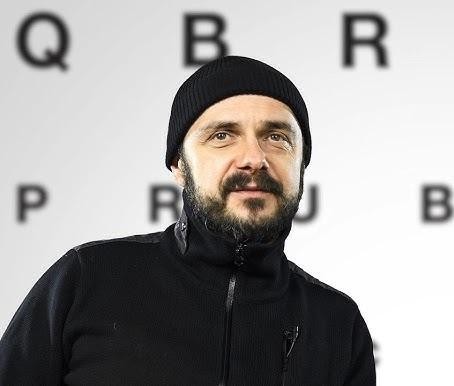 Zbliżenie na twarz Arkadiusza Jakubika z intensywnym wyrazem emocji, podkreślające jego kunszt aktorski i zdolność do wcielania się w różnorodne role.