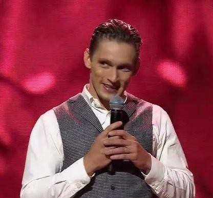 Filip Gurłacz w dynamicznej pozie podczas występu w programie telewizyjnym, być może tanecznym lub muzycznym show.