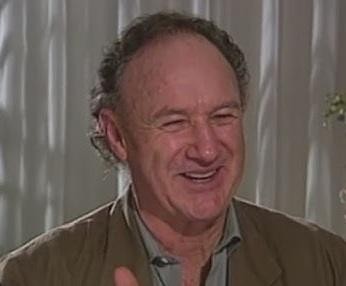 Gene Hackman w dynamicznej scenie filmowej, ukazujący intensywność i charyzmę, z jaką kreował swoje ikoniczne role.