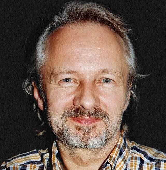 Krzysztof Stroiński w scenie filmowej lub serialowej, ukazujący intensywność aktorskiej kreacji.