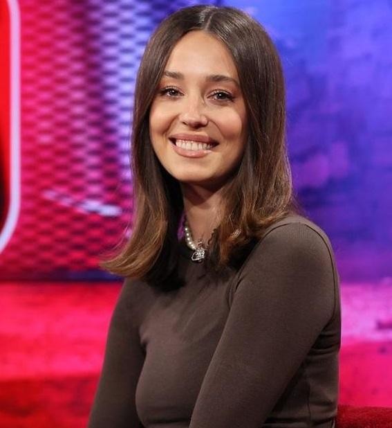 Izabella Krzan dynamicznie prezentująca w nowoczesnym studiu telewizyjnym Kanału Zero, symbolizującym jej przejście do nowych mediów.