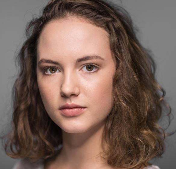 Martyna Byczkowska na planie filmowym lub teatralnym, podczas dynamicznej sceny, z intensywnym wyrazem twarzy.