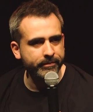 Abelard Giza w portrecie, z inteligentnym i zamyślonym wyrazem twarzy, w trakcie rozmowy lub występu.