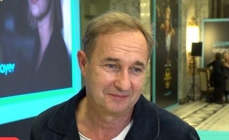 Marek Kalita w swoim domu w Puszczy Kampinoskiej, zrelaksowany, w otoczeniu natury.