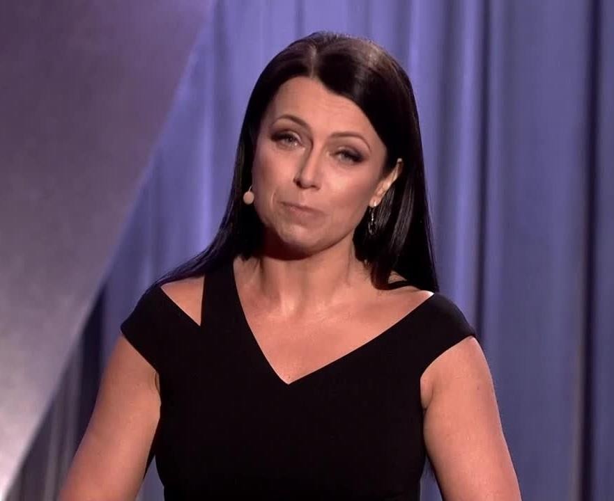 alt: Adrianna Borek na scenie, w trakcie występu kabaretowego, z charakterystyczną mimiką i gestykulacją, oddającą jej energię i komediowy talent.